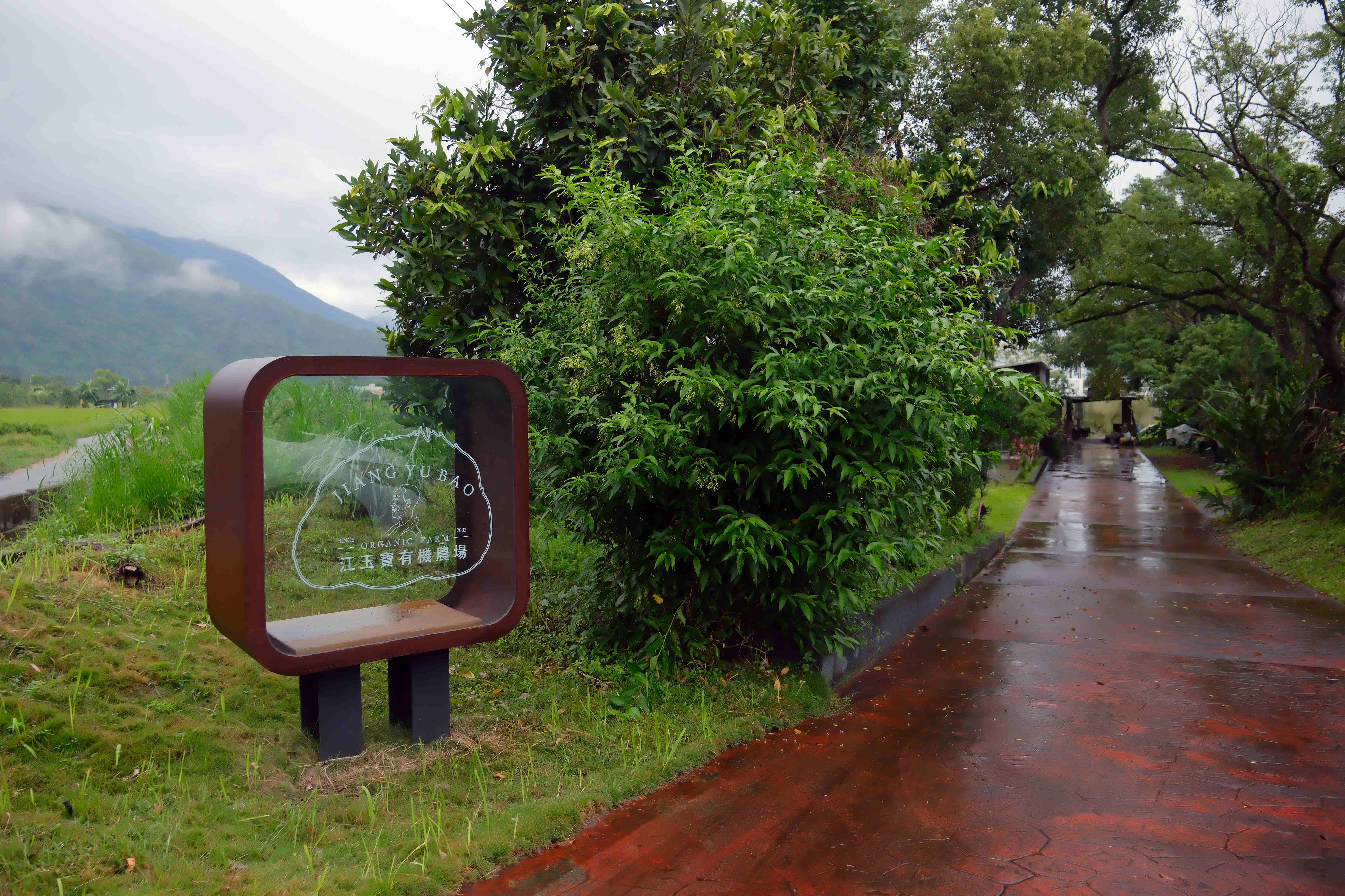 「江玉寶有機農場」入口標誌，遠眺中央山脈，景色怡人。