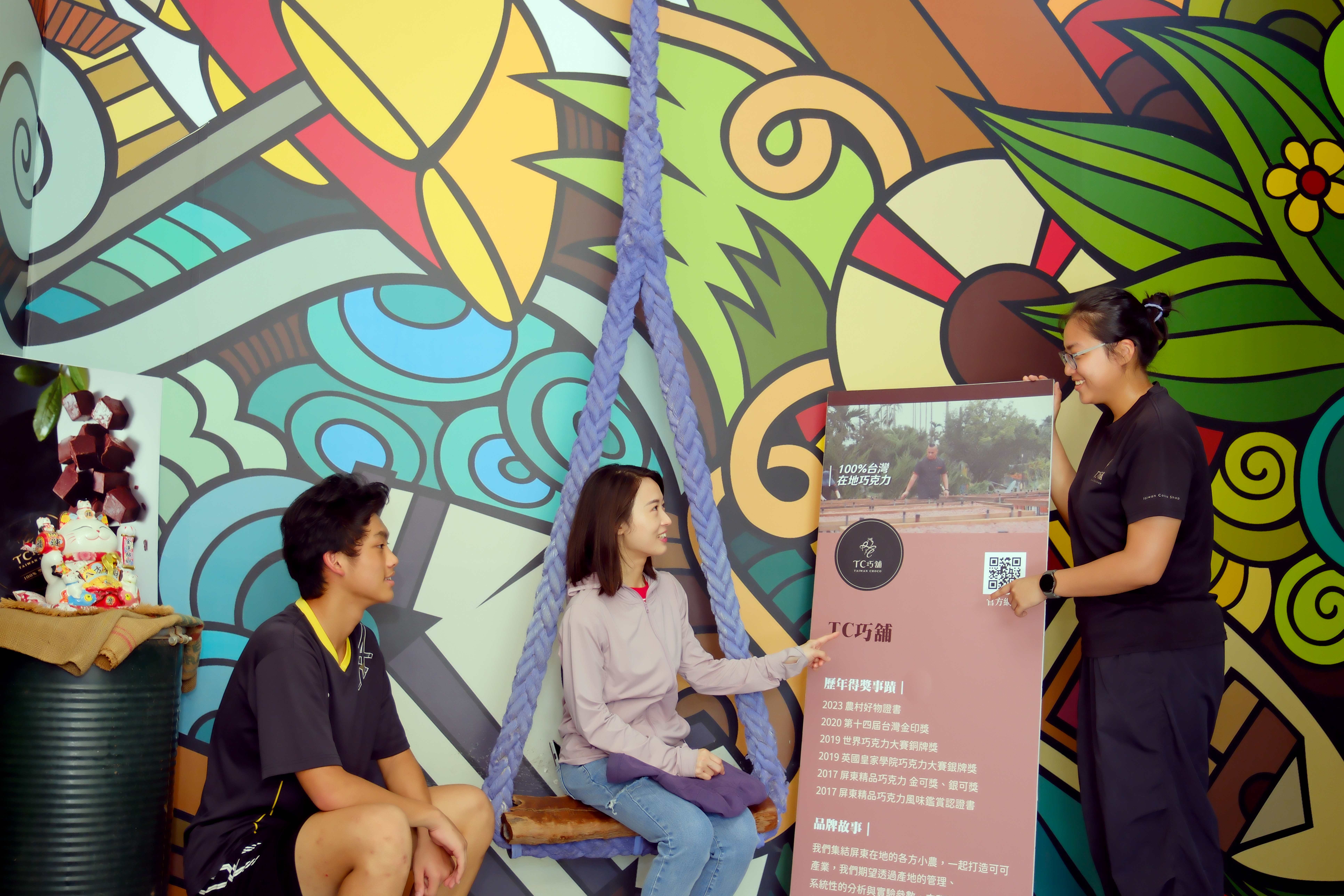 導覽員跟遊客解說「 TC 巧舖」的品牌故事。