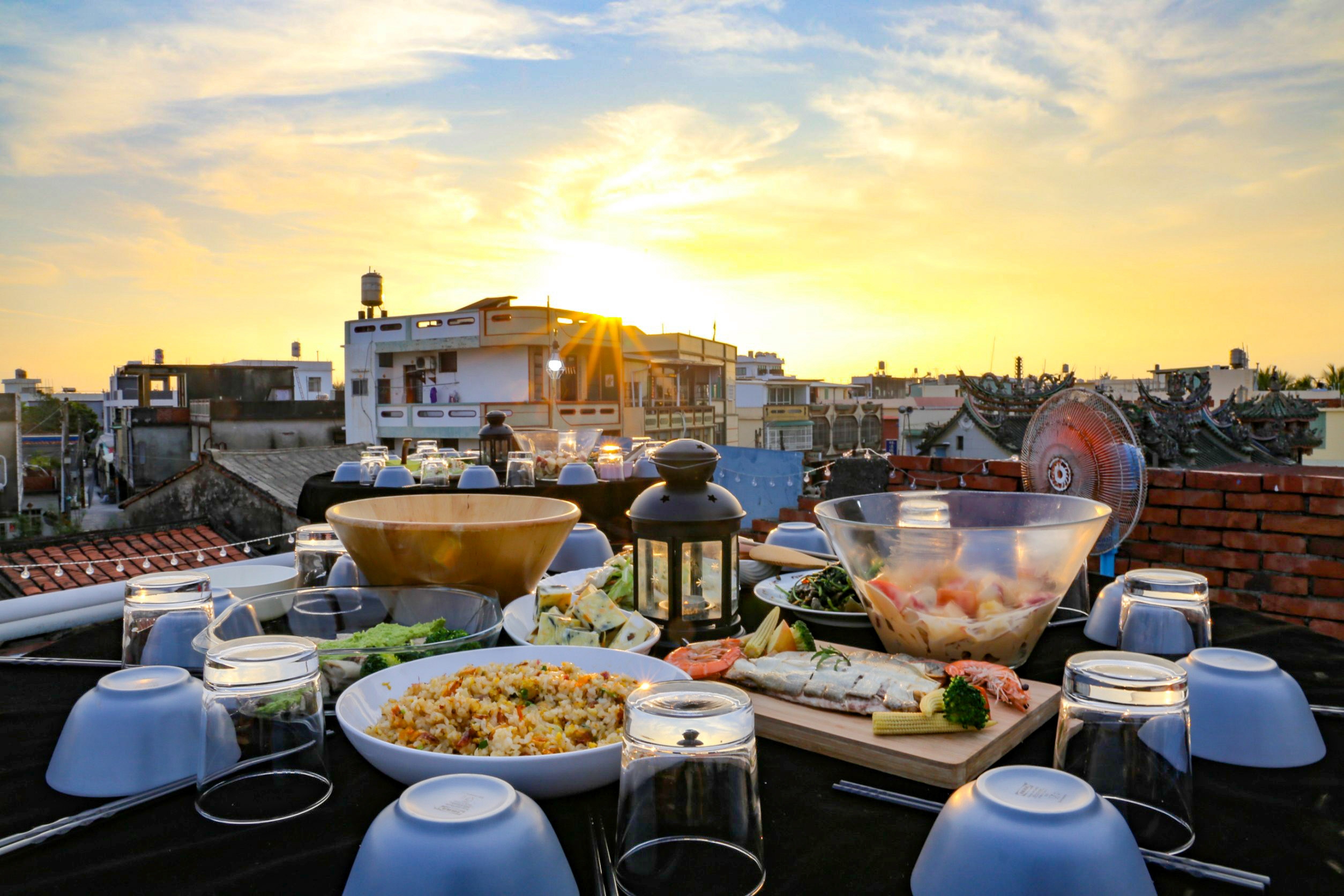 以在地食材為主的「夕陽海鮮晚宴」，在老雜貨店的樓頂上辦桌，飽覽漁村景致，看著落日品嘗最道地最新鮮的魚產盛宴。(大小港邊，熱帶漁林提供)